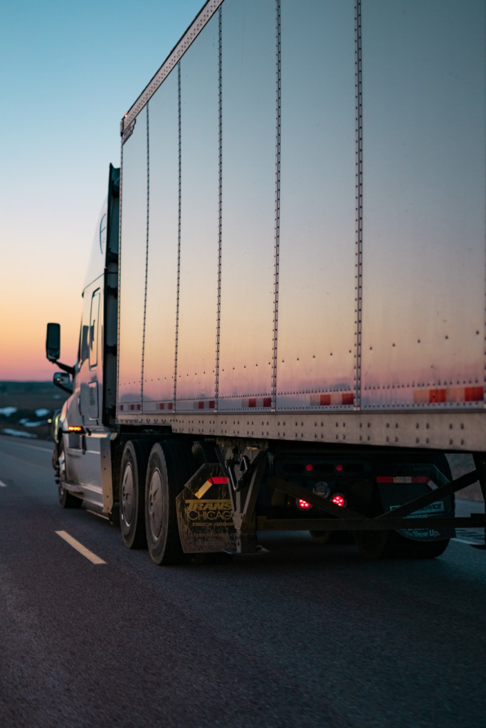 Semi-truck driving on highway at sunset representing logistics industry transformation case study