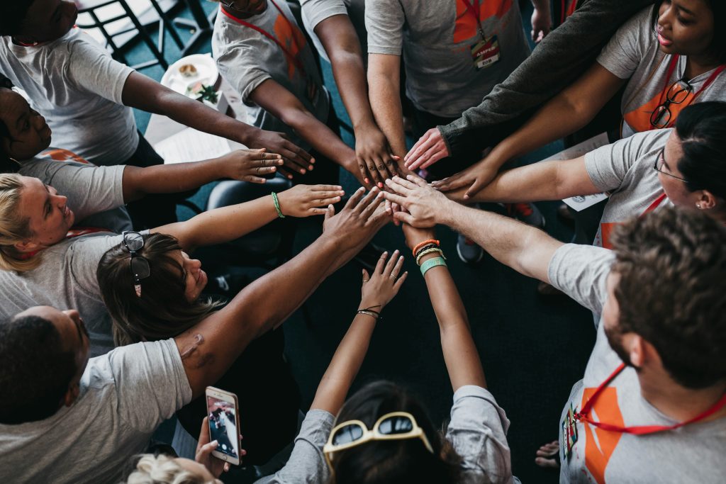 Team members stacking their hands together in a circle