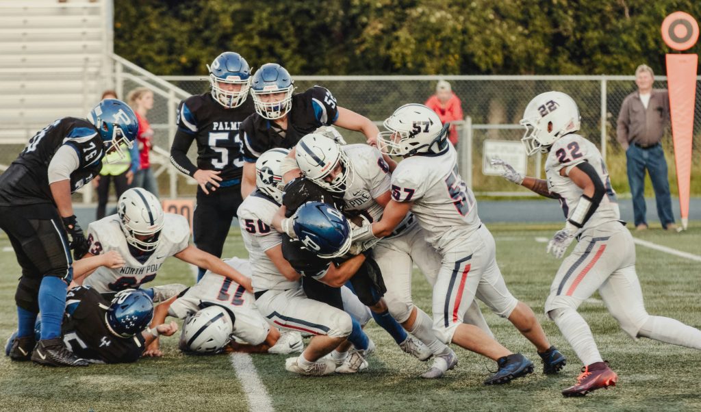 Football players colliding at the line of scrimmage